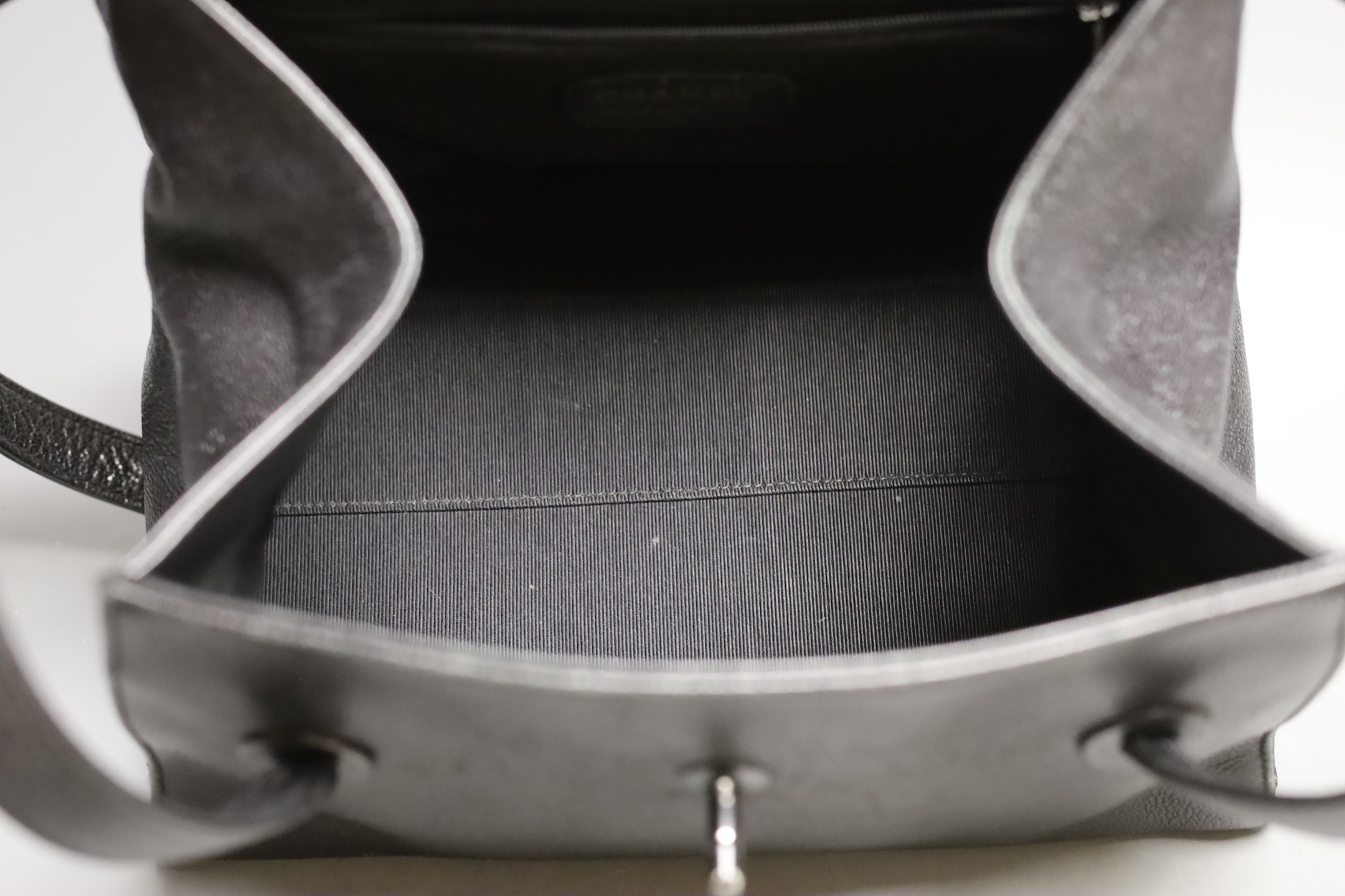 A black Chanel shoulder bag with two straps and Chanel logo lock